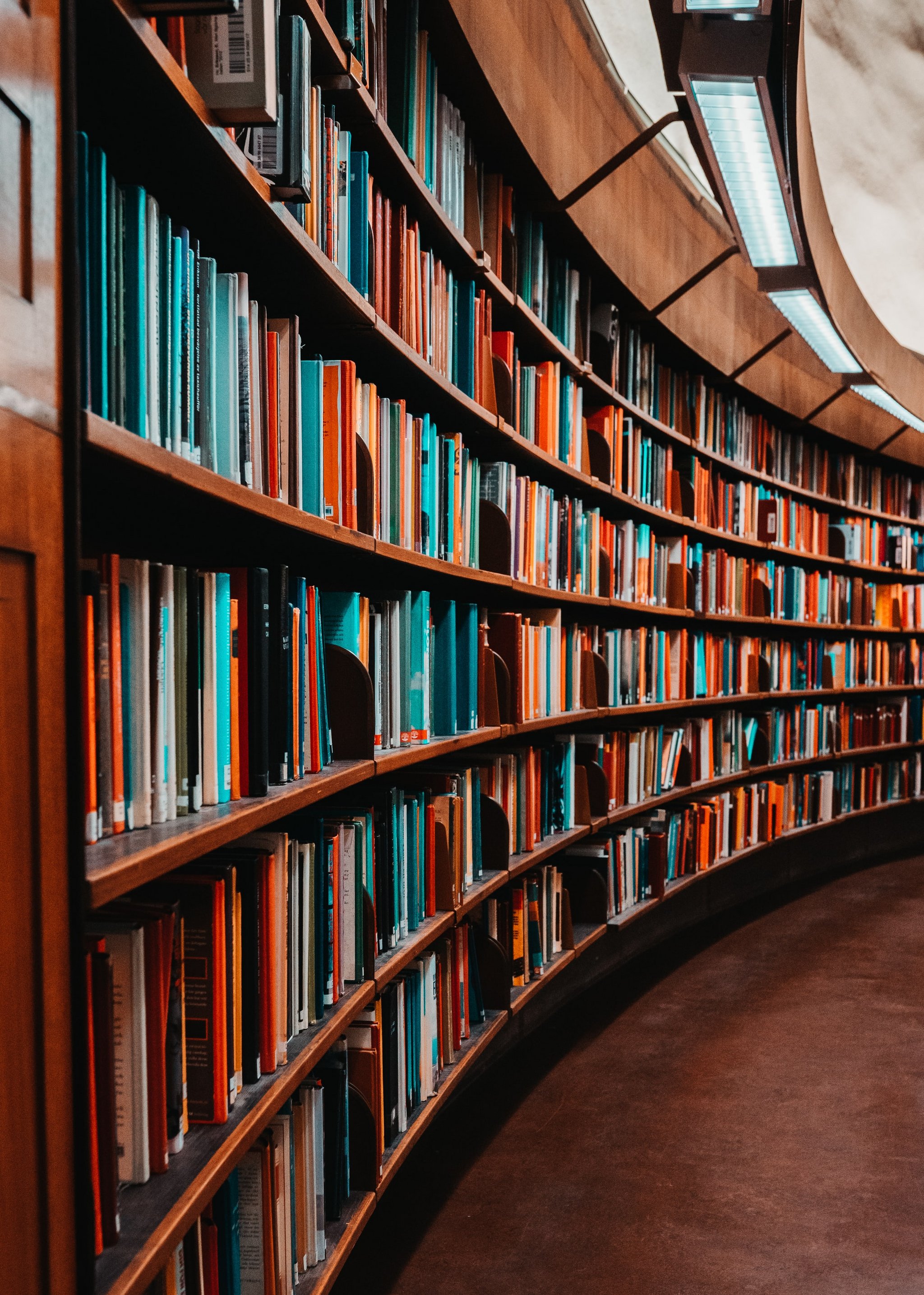 Bibliothek Das Bild zeigt Regalreihen mit Büchern in einer Bibliothek